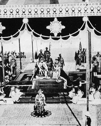 Their Imperial Majesties the Emperor George V and Empress Mary seated on the imperial thrones while they receive allegience from five hundred plus Princes of Royal India. 